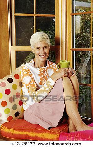 Portrait of a senior woman holding a cup and smiling View Large Photo Image Stock Image - Portrait of a senior woman holding a cup and smiling. Fotosearch