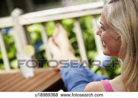 Rear view of a mature woman smiling View Large Photo Image Stock Photo - Rear view of a mature woman smiling. Fotosearch