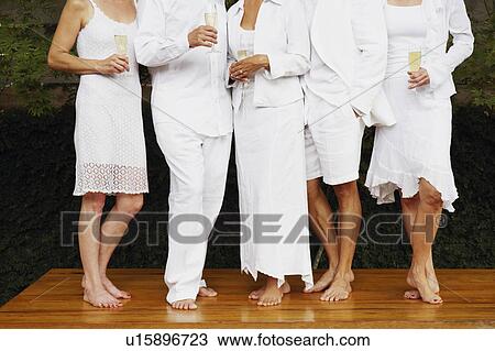 Two men and three women standing side by side on the table View Large Photo Image Stock Image - Two men and three women standing side by side on the table. Fotosearch