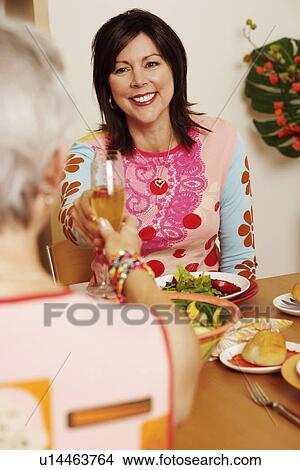 Mature woman and her friend toasting with champagne flutes View Large Photo Image Picture - Mature woman and her friend toasting with champagne flutes. Fotosearch