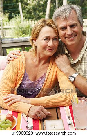Stock Photo - Portrait of a mature couple sitting at the table. Fotosearch