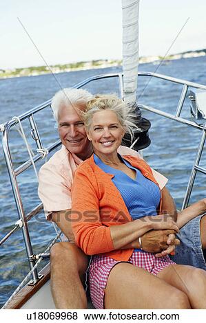 Portrait of a mature man embracing a mature woman from behind in a boat and smiling View Large Photo Image Stock Photo - Portrait of a mature man embracing a mature woman from behind in a boat and smiling. Fotosearch
