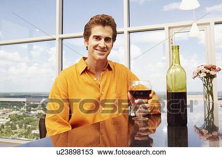 Portrait of a mature man holding a glass of wine and smiling View Large Photo Image Stock Image - Portrait of a mature man holding a glass of wine and smiling. Fotosearch