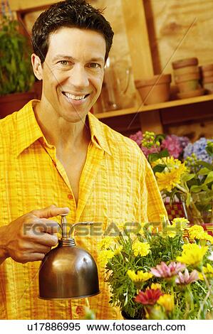 Portrait of a mature man spraying water over potted plants View Large Photo Image Stock Photography - Portrait of a mature man spraying water over potted plants. Fotosearch