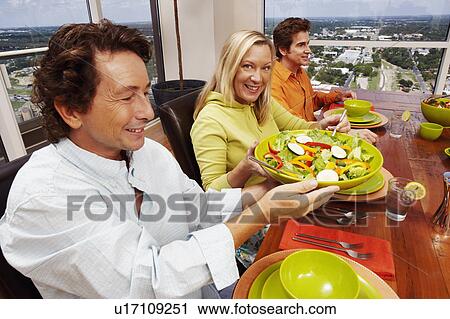 Portrait of a mature woman and two mature men sitting at the dining table View Large Photo Image Stock Image - Portrait of a mature woman and two mature men sitting at the dining table. Fotosearch