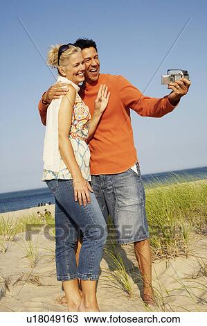 Mature couple taking a picture of themselves on the beach View Large Photo Image Stock Image - Mature couple taking a picture of themselves on the beach. Fotosearch