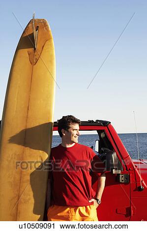 Mature man leaning against a sports utility vehicle with a surfboard View Large Photo Image Stock Image - Mature man leaning against a sports utility vehicle with a surfboard. Fotosearch