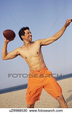 Mature man playing football on the beach View Large Photo Image Stock Image - Mature man playing football on the beach. Fotosearch