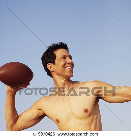 Stock Photograph - Mature man playing football. Fotosearch