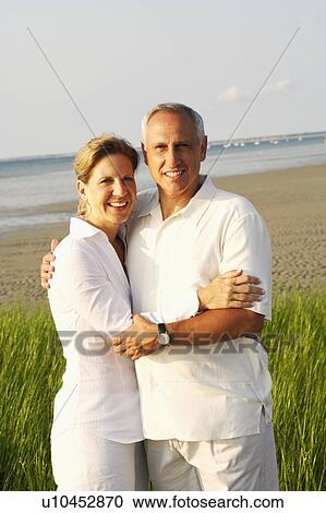 Portrait of a mature couple embracing on the beach and smiling View Large Photo Image Stock Image - Portrait of a mature couple embracing on the beach and smiling. Fotosearch