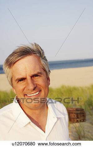 Portrait of a mature man smiling on the beach View Large Photo Image Stock Image - Portrait of a mature man smiling on the beach. Fotosearch