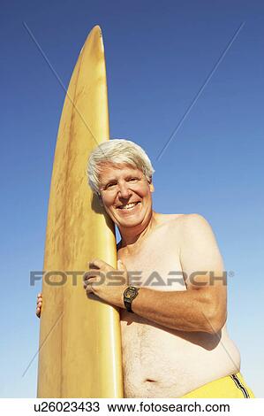 Portrait of a mature man holding a surfboard and smiling View Large Photo Image Stock Image - Portrait of a mature man holding a surfboard and smiling. Fotosearch