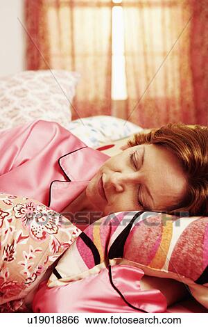 Close-up of a mature woman sleeping on the bed View Large Photo Image Stock Photograph - Close-up of a mature woman sleeping on the bed. Fotosearch