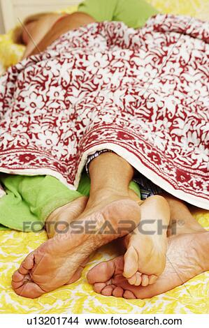 Close-up of the feet of a couple sleeping on the bed View Large Photo Image Picture - Close-up of the feet of a couple sleeping on the bed. Fotosearch