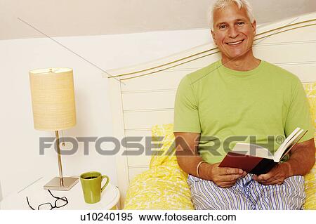 Portrait of a mature man sitting on the bed and smiling View Large Photo Image Stock Photography - Portrait of a mature man sitting on the bed and smiling. Fotosearch