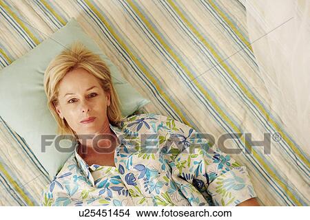 Portrait of a mature woman lying in bed View Large Photo Image Picture - Portrait of a mature woman lying in bed. Fotosearch