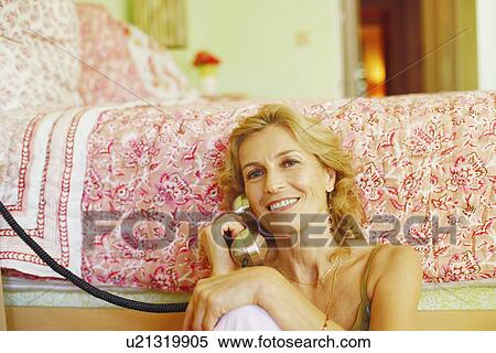 Portrait of a mature woman talking on the telephone View Large Photo Image Stock Photography - Portrait of a mature woman talking on the telephone. Fotosearch