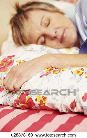 Stock Photo - Close-up of a mature woman sleeping on the bed. Fotosearch