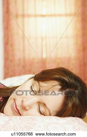 Stock Photograph - Close-up of a mature woman sleeping on the bed. Fotosearch