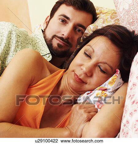 Close-up of a mature woman sleeping with a mature man lying behind her View Large Photo Image Stock Image - Close-up of a mature woman sleeping with a mature man lying behind her. Fotosearch