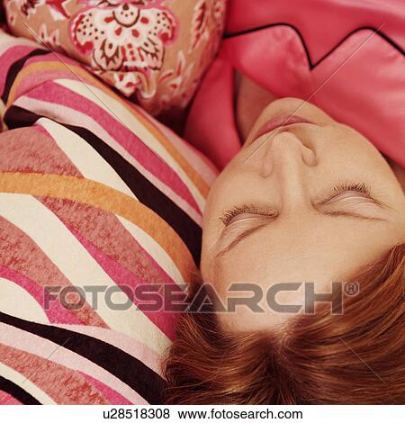 Stock Photo - High angle view of a mature woman sleeping on the bed. Fotosearch