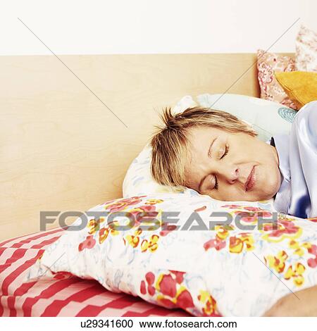 Stock Image - Mature woman sleeping on the bed. Fotosearch
