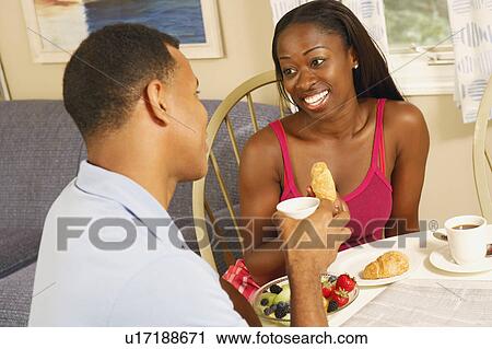 Stock Image - Mid adult woman and a mature man having breakfast. Fotosearch