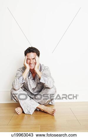 Portrait of a mature man sitting cross-legged on the floor and making a face View Large Photo Image Stock Image - Portrait of a mature man sitting cross-legged on the floor and making a face. Fotosearch