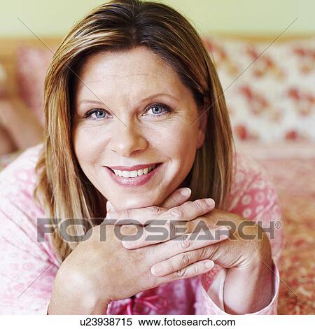 Portrait of a mature woman lying on the bed and smiling View Large Photo Image Stock Photography - Portrait of a mature woman lying on the bed and smiling. Fotosearch