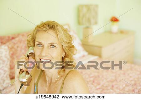 Portrait of a mature woman talking on the telephone View Large Photo Image Stock Image - Portrait of a mature woman talking on the telephone. Fotosearch
