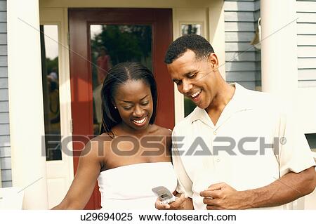 Close-up of a mature man and a mid adult woman looking at a mobile phone View Large Photo Image Stock Photography - Close-up of a mature man and a mid adult woman looking at a mobile phone. Fotosearch