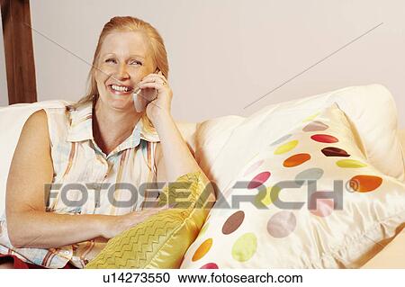Close-up of a mature woman talking on a mobile phone and smiling View Large Photo Image Stock Image - Close-up of a mature woman talking on a mobile phone and smiling. Fotosearch