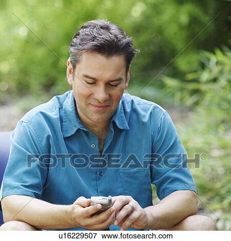 Stock Photo - Mature man using a mobile phone. Fotosearch