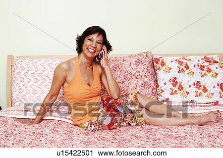 Portrait of a mature woman talking on a mobile phone and smiling View Large Photo Image Stock Image - Portrait of a mature woman talking on a mobile phone and smiling. Fotosearch