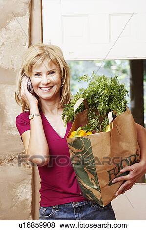 Stock Photo - Portrait of a mature woman talking on a mobile phone and smiling. Fotosearch