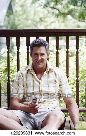 Portrait of a mid adult man holding a mobile phone and smiling View Large Photo Image Stock Image - Portrait of a mid adult man holding a mobile phone and smiling. Fotosearch