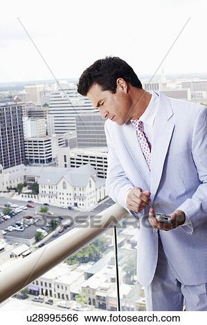 Businessman holding a personal data assistant View Large Photo Image Stock Photograph - Businessman holding a personal data assistant. Fotosearch