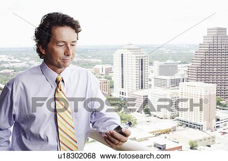 Close-up of a businessman looking at a mobile phone View Large Photo Image Stock Photo - Close-up of a businessman looking at a mobile phone. Fotosearch