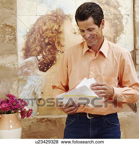 Stock Photo - Mature woman checking mail and smiling. Fotosearch