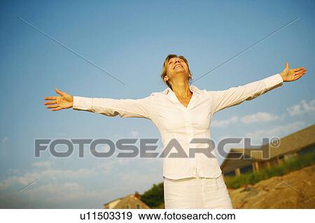 Mature woman smiling with her arms outstretched View Large Photo Image Stock Photo - Mature woman smiling with her arms outstretched. Fotosearch