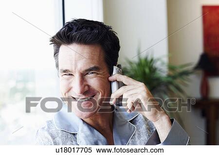 Portrait of a mature man talking on a mobile phone and smiling View Large Photo Image Stock Photography - Portrait of a mature man talking on a mobile phone and smiling. Fotosearch