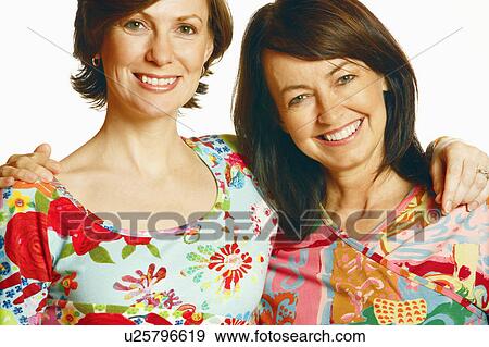 Portrait of a mid adult woman and a mature woman with their arm around each other and smiling View Large Photo Image Stock Photo - Portrait of a mid adult woman and a mature woman with their arm around each other and smiling. Fotosearch