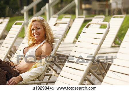 Side profile of a mature woman reclining on a lounge chair View Large Photo Image Stock Photography - Side profile of a mature woman reclining on a lounge chair. Fotosearch