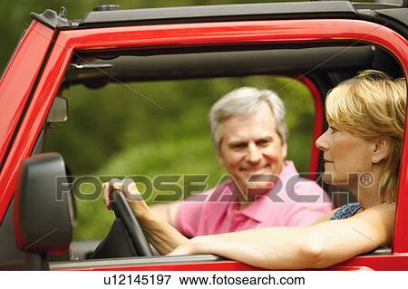 Close-up of a mature couple smiling in a sports utility vehicle View Large Photo Image Stock Photo - Close-up of a mature couple smiling in a sports utility vehicle. Fotosearch