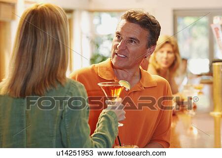 Close-up of a mature man talking to a woman in a bar View Large Photo Image Stock Image - Close-up of a mature man talking to a woman in a bar. Fotosearch
