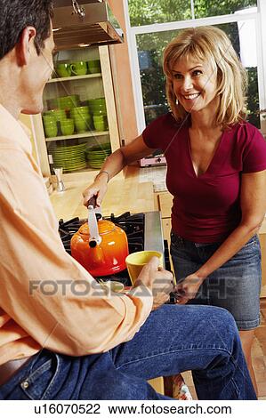 Close-up of a mature woman holding a kettle with a mature man holding a cup of tea View Large Photo Image Stock Image - Close-up of a mature woman holding a kettle with a mature man holding a cup of tea. Fotosearch