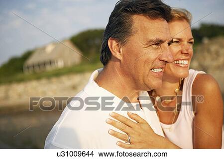 Close-up of a mid adult woman and a mature man smiling View Large Photo Image Picture - Close-up of a mid adult woman and a mature man smiling. Fotosearch