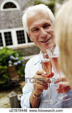 Stock Photo - Mature couple holding champagne flutes. Fotosearch