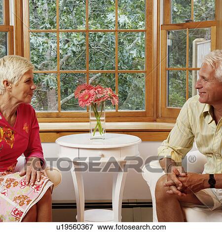 mature man and a senior woman sitting on chairs and looking at each other View Large Photo Image Stock Photo - mature man and a senior woman sitting on chairs and looking at each other. Fotosearch