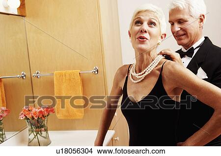 Mature man putting a pearl necklace around a senior woman's neck View Large Photo Image Picture - Mature man putting a pearl necklace around a senior woman's neck. Fotosearch